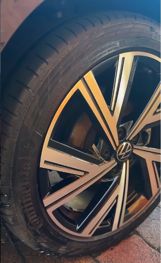 Close-up of a Volkswagen vehicle wheel with black and gold alloy rim and Continental tire