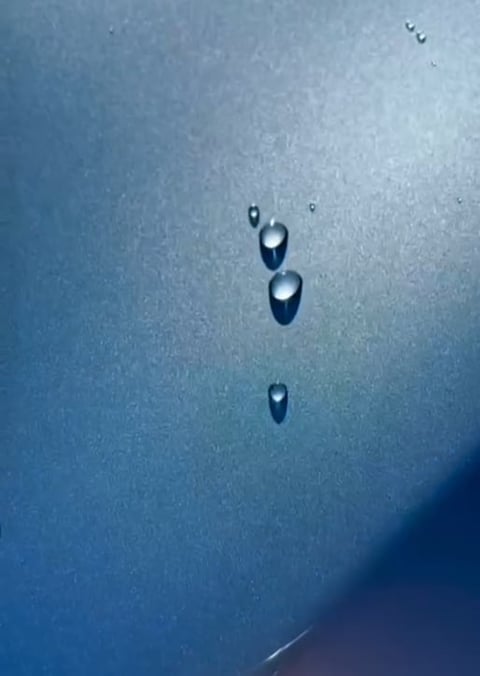 Water droplets falling on a blue gradient surface