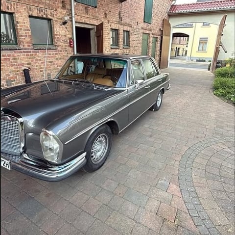Vintage gray Mercedes-Benz sedan parked in brick courtyard