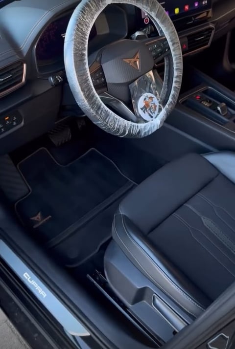 Car interior with protective plastic steering wheel cover and custom floor mats